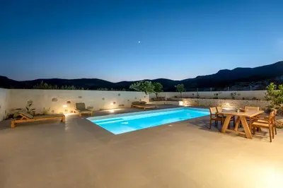 a villa with a swimming pool at night at Villa Froudi in Kissamos