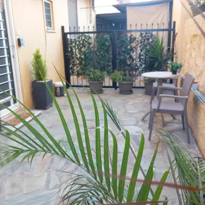 a patio with a table and chairs and potted plants at Studio Victory Chania in Chania Town
