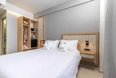 a bedroom with a large white bed with white pillows at Metropolitan Pearl Boutique Hotel in Chania Town