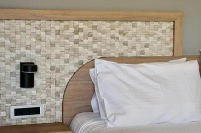 a headboard of a bed with a white pillow at Metropolitan Pearl Boutique Hotel in Chania Town