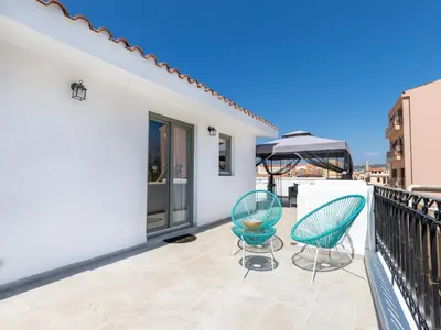 a balcony with two chairs and an umbrella at Metropolitan Pearl Boutique Hotel in Chania Town