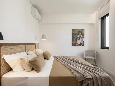 a bedroom with a bed with white walls and a window at JnV Luxury Villas in Chania Town