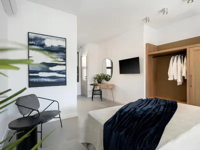a bedroom with a bed and a chair and a table at JnV Luxury Villas in Chania Town