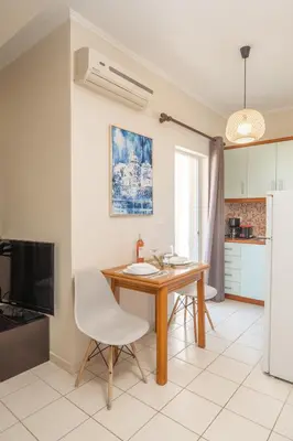 a kitchen and dining room with a wooden table and chairs at Ammoutsiani Cozy Apartment 1 by 8essentially in Chania Town