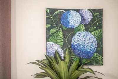 a painting of blue flowers on a wall at Ammoutsiani Cozy Apartment 1 by 8essentially in Chania Town