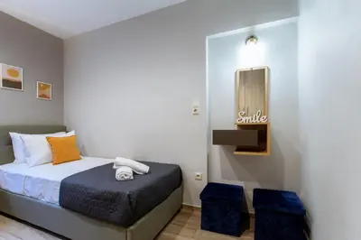 a small bedroom with a bed and two blue stools at Kares Dream House in Chania Town