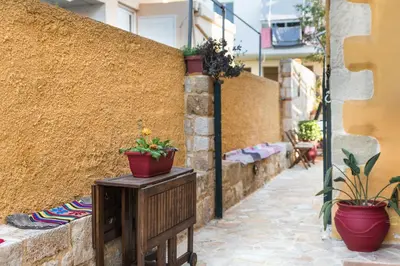 a side walk with potted plants on a wall at Dominic Chania 3 Room Apartment in Chania Town