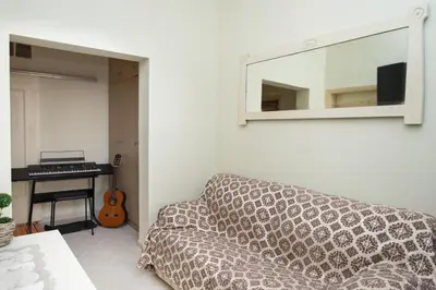 a living room with a couch and a mirror and a keyboard at Dominic Chania 3 Room Apartment in Chania Town