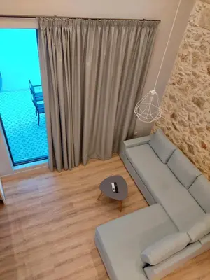 a living room with a couch and a table at TheJoy Residence Apartments in Chania Town