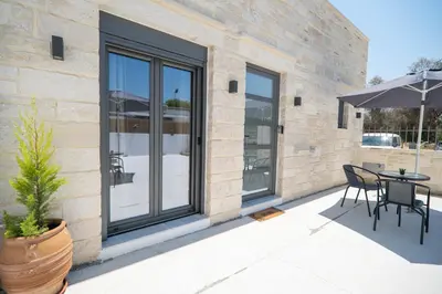 a patio with a table and chairs and an umbrella at Kiani Apts in Kalyves