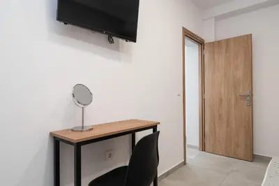 a room with a desk with a mirror and a chair at Kiani Apts in Kalyves