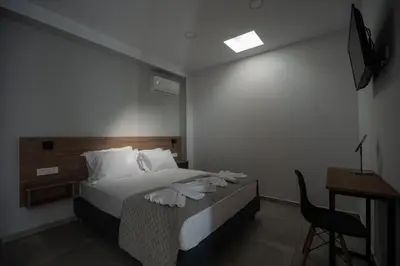 a bedroom with a bed and a desk and a chair at Kiani Apts in Kalyves
