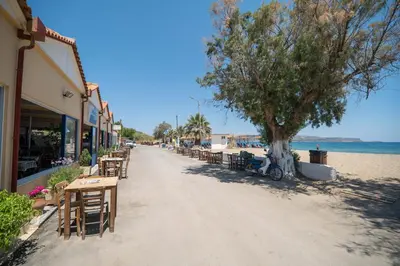 a street with tables and chairs on the beach at Kiani Apts in Kalyves