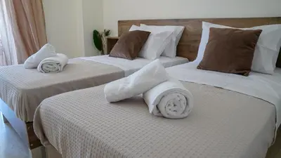 two beds with white towels on top of them at KM Beach View apartment in Chania Town
