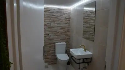 a bathroom with a white toilet and a sink at KM Beach View apartment in Chania Town