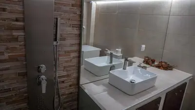 a bathroom with two sinks and a mirror at KM Beach View apartment in Chania Town