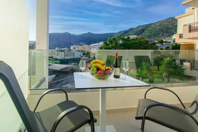 a table with a bowl of bananas and a bottle of wine at Vakakis Family Luxury Studios 2 in Palaiochóra