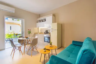a living room with a blue couch and a kitchen at Vakakis Family Luxury Studios 2 in Palaiochóra
