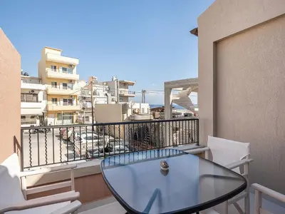 a glass table on a balcony with a view at Mythodea Luxury Suites in Chania Town