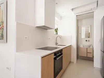 a white kitchen with a sink and a stove at Mythodea Luxury Suites in Chania Town