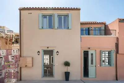 a pink house with a potted plant in front of it at Mythodea Luxury Suites in Chania Town