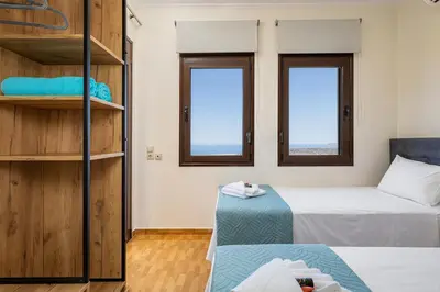 a small room with a bed and two windows at Villa Lia Chania with private ecologic pool and amazing view! in Chania Town