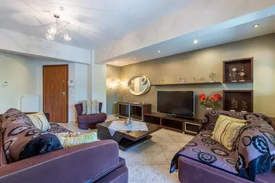 a living room with two couches and a tv at Elena Apartment in Chania Town