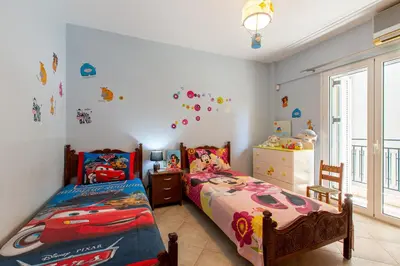 a bedroom with two twin beds and a window at Elena Apartment in Chania Town