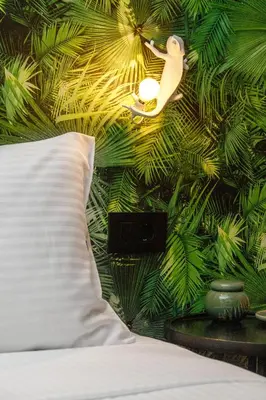 a bedroom with a green wall with a bird on it at Mimosa Urban Habitation in Chania Town