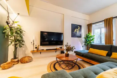 a living room with a couch and a tv at Mimosa Urban Habitation in Chania Town