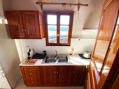 a small kitchen with a sink and a window at Dusk Apartments with Stunning Mountain View in Chania Town