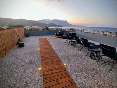 a patio with chairs and a table and the ocean at Blue Horizon Kisamos Deluxe Apartment in Kissamos
