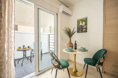 a living room with a table and chairs and a window at MYRTIA APARTMENT few steps from the sea in Chania Town