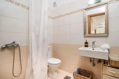 a bathroom with a toilet and a sink and a mirror at MYRTIA APARTMENT few steps from the sea in Chania Town