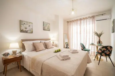 a bedroom with a bed and a table and a chair at MYRTIA APARTMENT few steps from the sea in Chania Town
