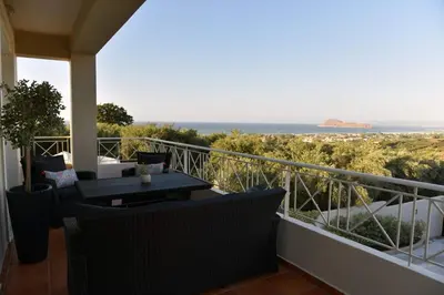 a balcony with a table and chairs and the ocean at VILLA BLUE VEDERE in Gerani Chanion