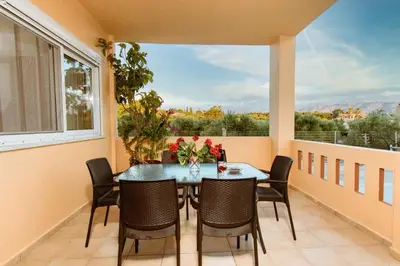 a dining room with a table and chairs and a large window at OLIVE TREE in Galatás