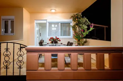 a room with a table and a balcony with flowers at OLIVE TREE in Galatás