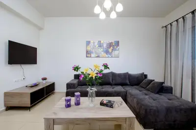 a living room with a couch and a table with flowers at OLIVE TREE in Galatás