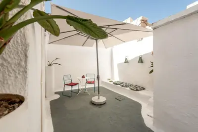 a patio with a table and an umbrella at Casa Lion in Chania Town