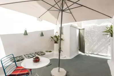 a white room with a table and an umbrella at Casa Lion in Chania Town