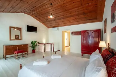 a bedroom with a white bed and a wooden ceiling at Casa Lion in Chania Town