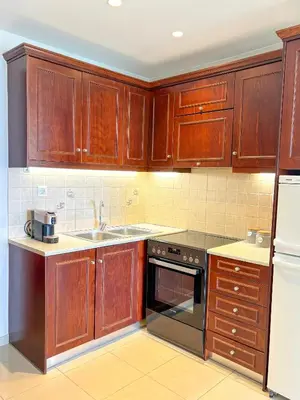 a kitchen with wooden cabinets and a sink at Vista Mare in Palaiochóra