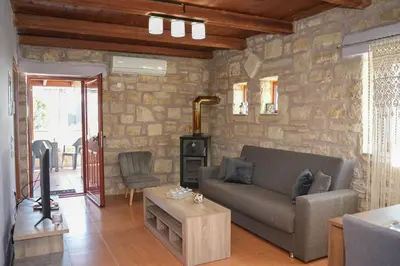 a living room with a couch and a stone wall at SundayMar Stone House in Chania Town