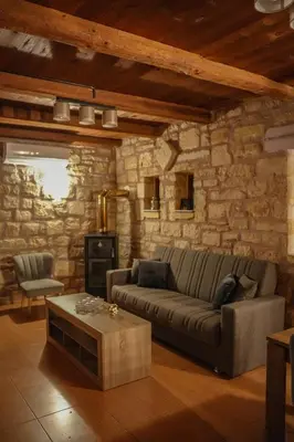 a living room with a couch and a stone wall at SundayMar Stone House in Chania Town