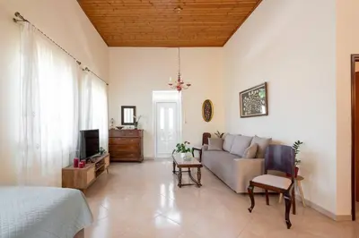 a living room with a couch and a tv at Manos Home in Spiliá
