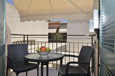a table with chairs and a bowl of fruit on a balcony at Amara Porto Living in Chania Town