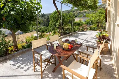 a table and chairs with a bowl of fruit on a patio at Casa Alta 2-bedroom House in Manoliópoulon