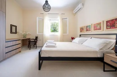 a bedroom with a large bed and a table at Casa Alta 2-bedroom House in Manoliópoulon