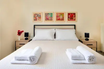 a bedroom with a white bed with towels on it at Casa Alta 2-bedroom House in Manoliópoulon